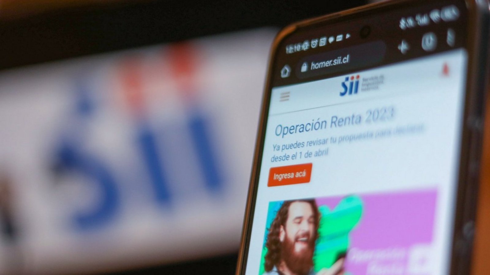 Celular y pantalla con pestaña abierta de la web del Servicio de Impuestos Internos (SII)