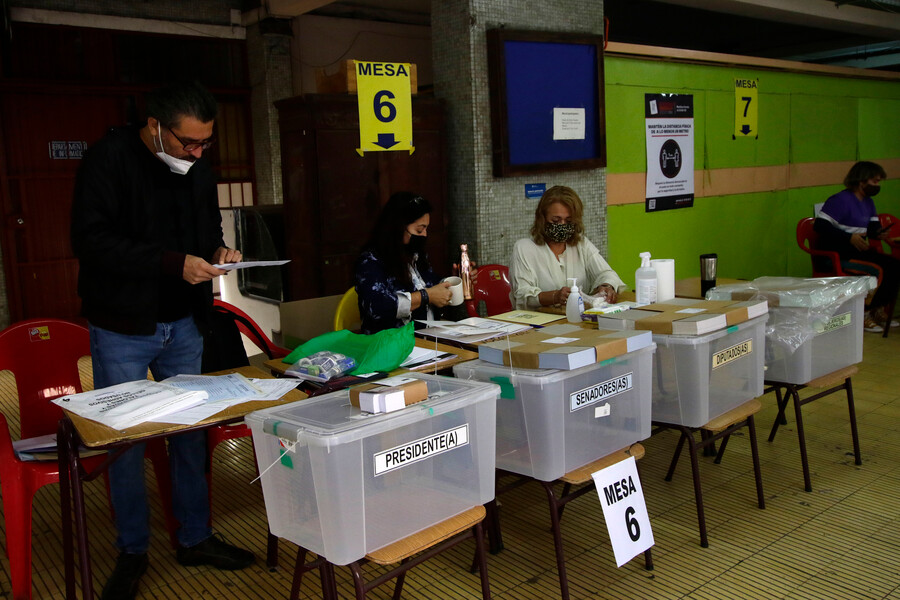 Tres personas desempeñándose como vocales de mesa en elecciones.