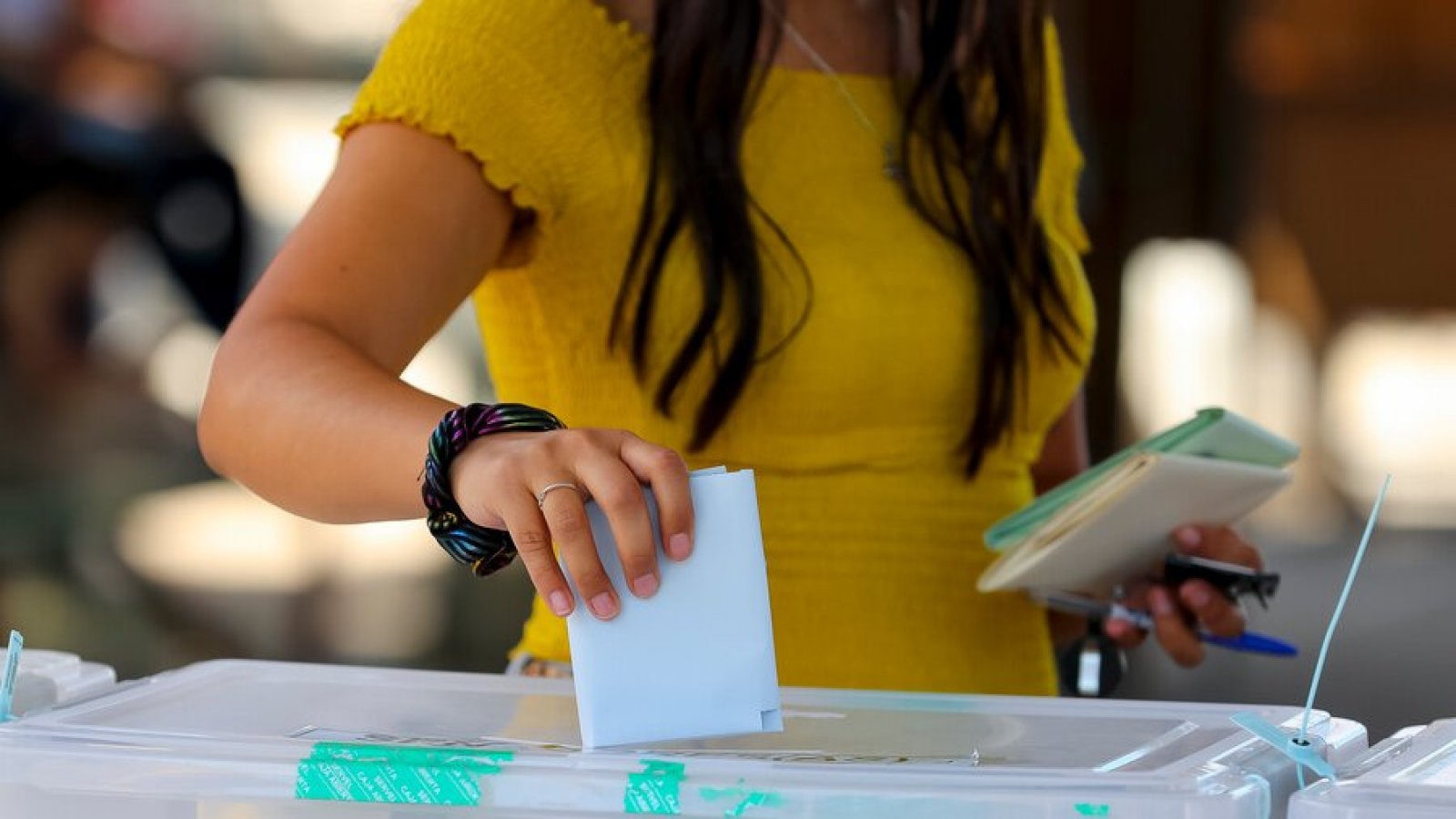 Mujer ingresando su voto en una urna.