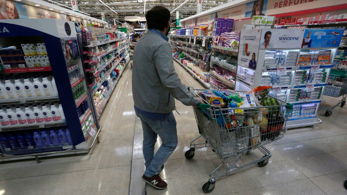 Hombre con un carro comprando en supermercado