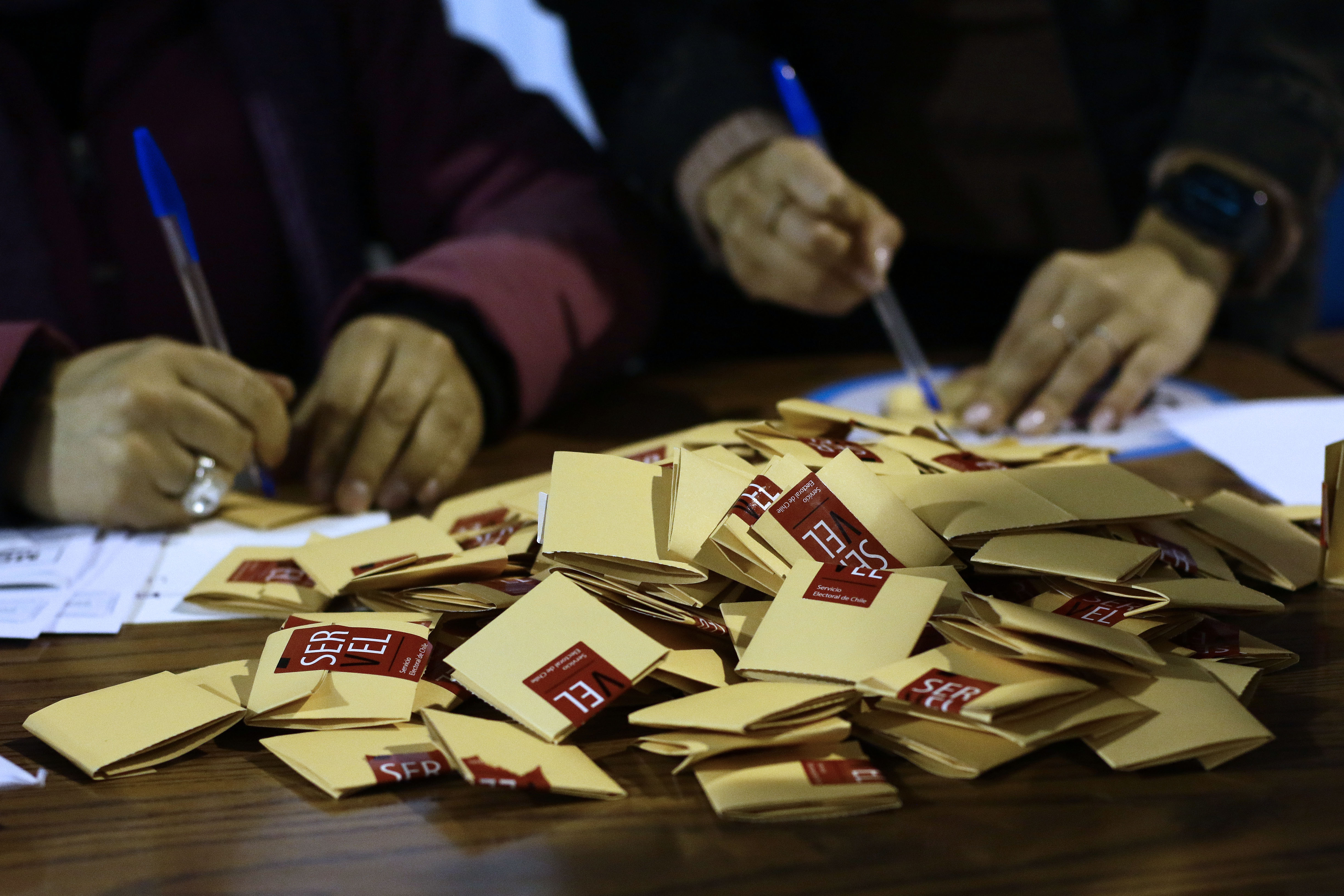 Votos electorales arriba de una mesa de votación.