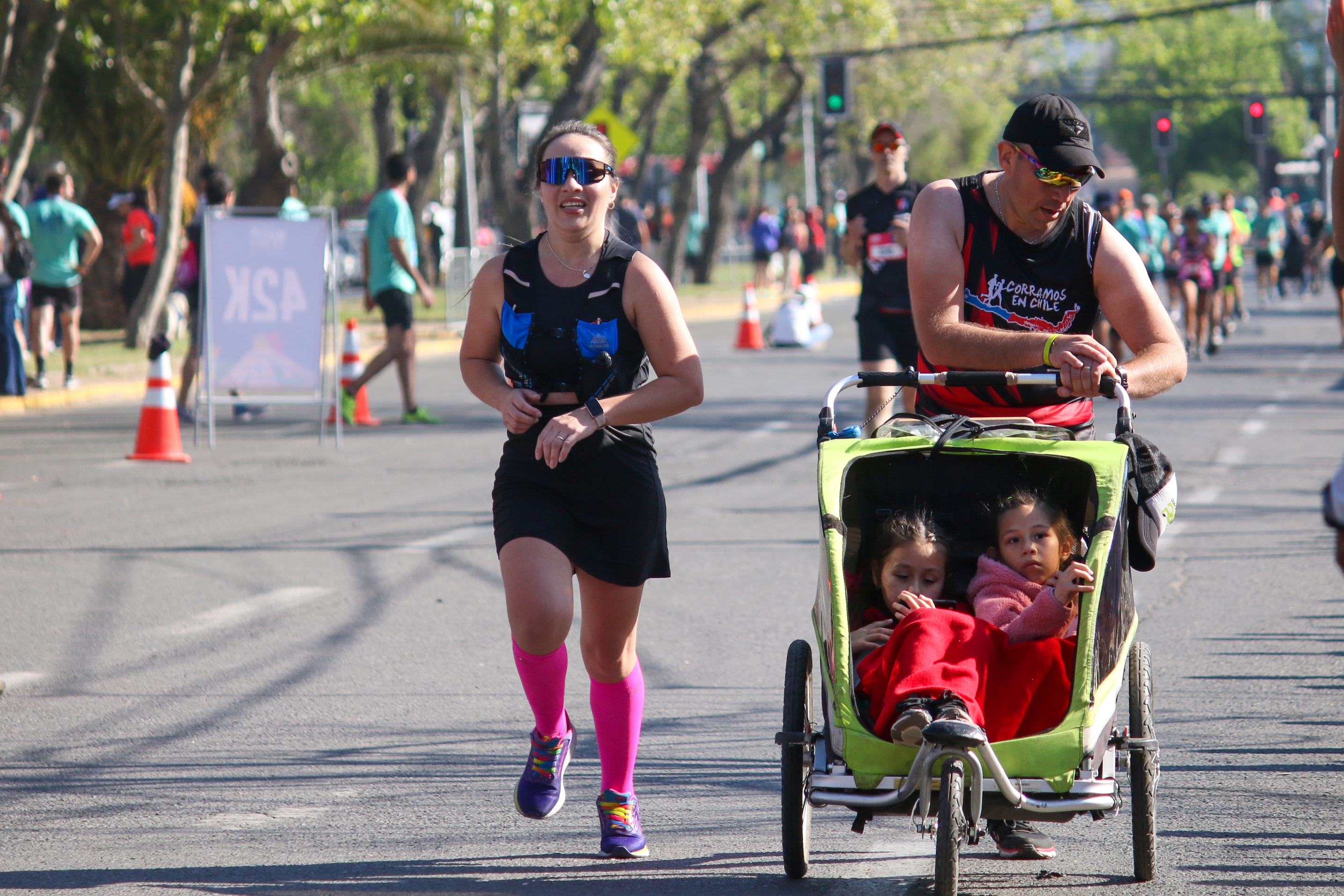 Mujer y Hombre corriendo con un coche de bebe.