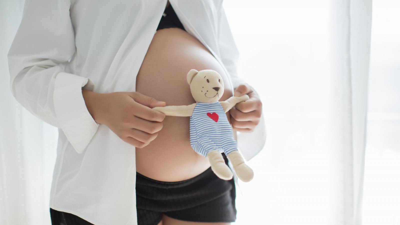 Mujer embarazada con un peluche.