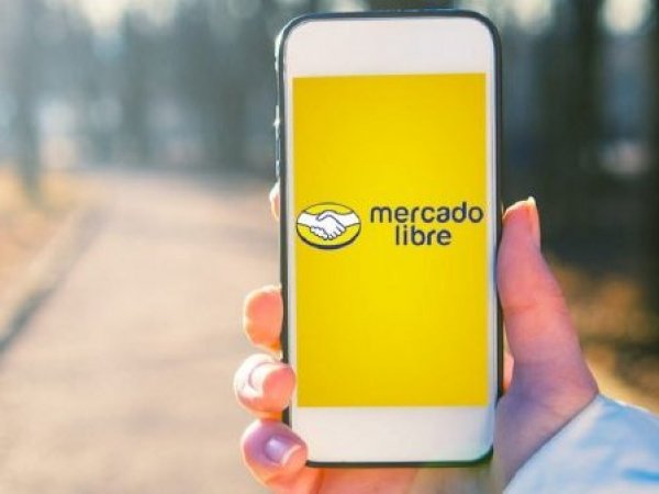 Mano sosteniendo celular con app de Mercado Libre abierta