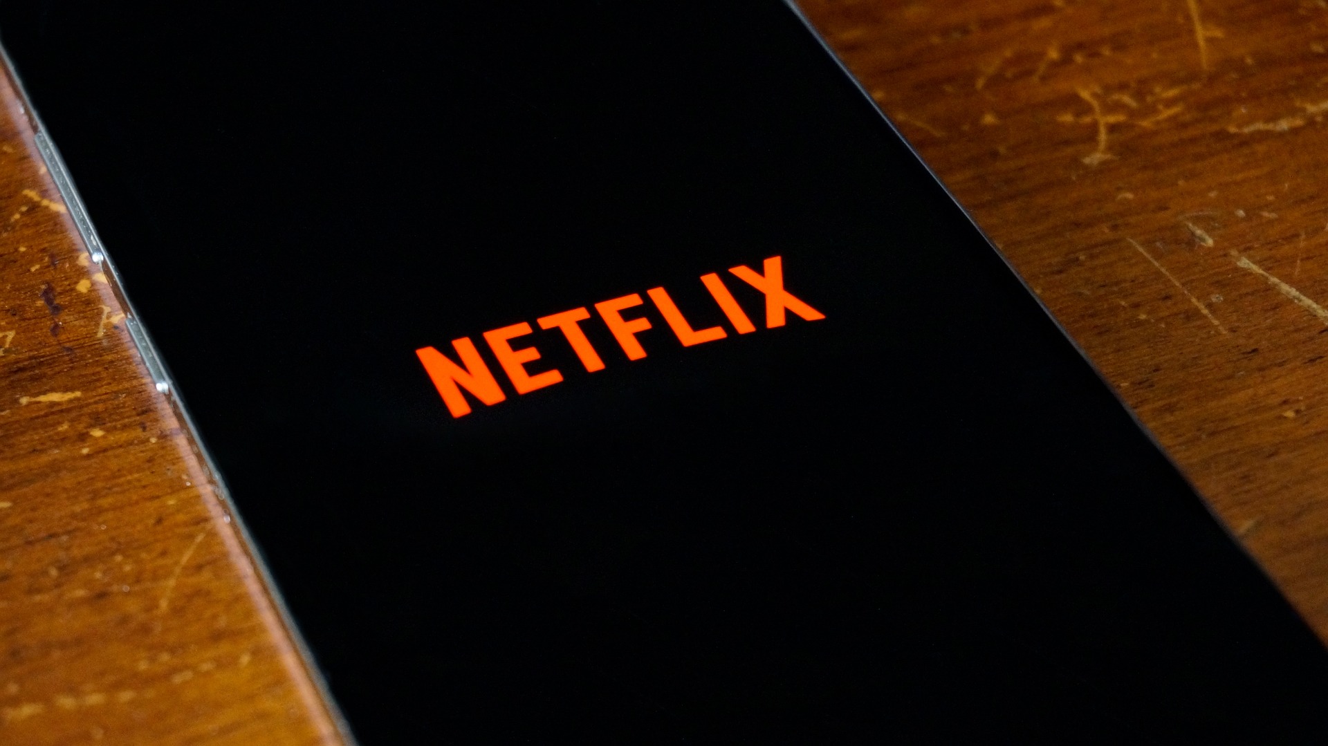 Celular sobre una mesa y con la imagen de Netflix.