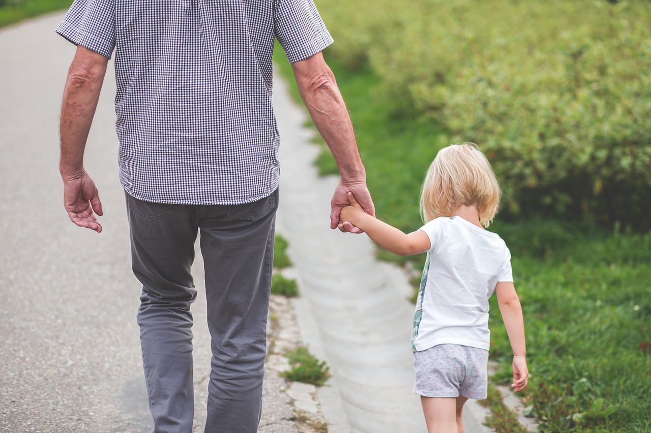 Padre e hija caminado de la mano