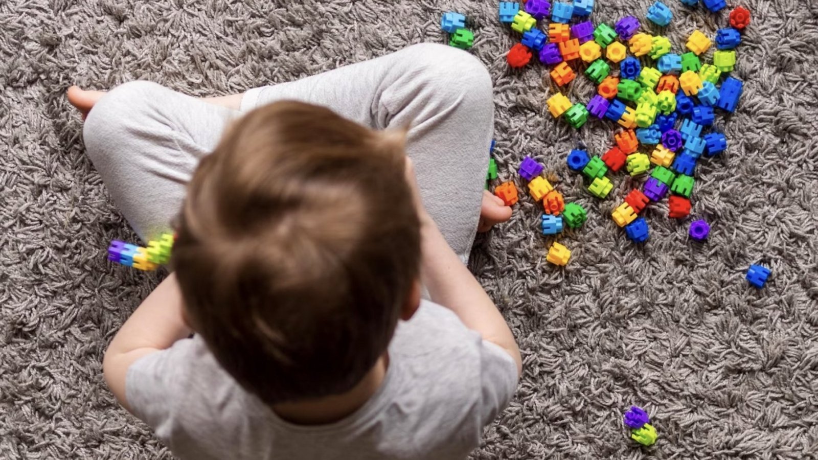 Niño jugando con piezas de colores.