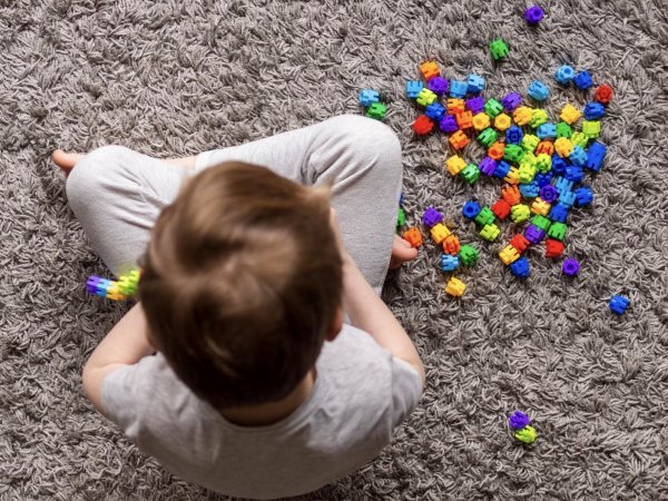 Niño jugando con piezas de colores.