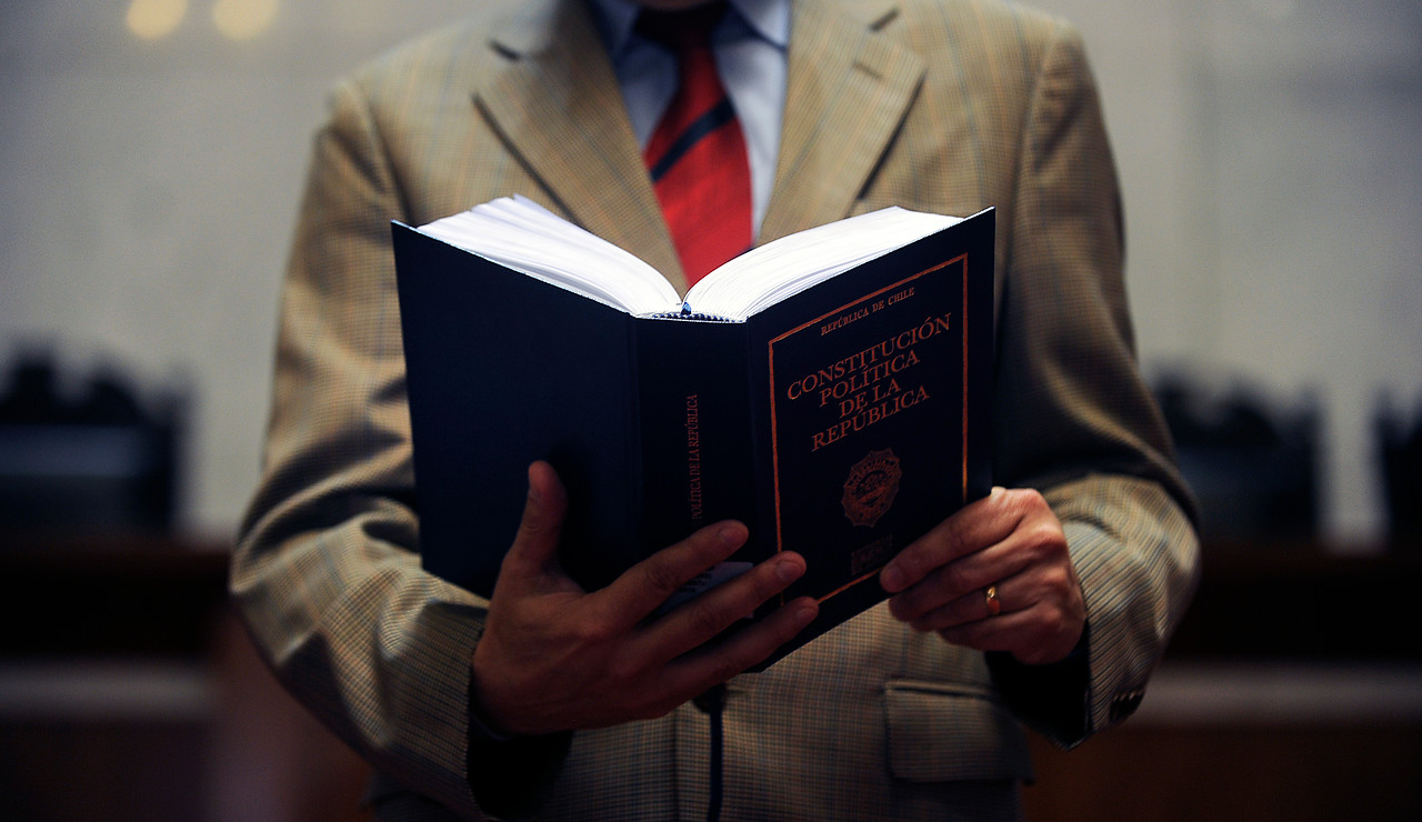 Hombre leyendo la Constitución Política de Chile.