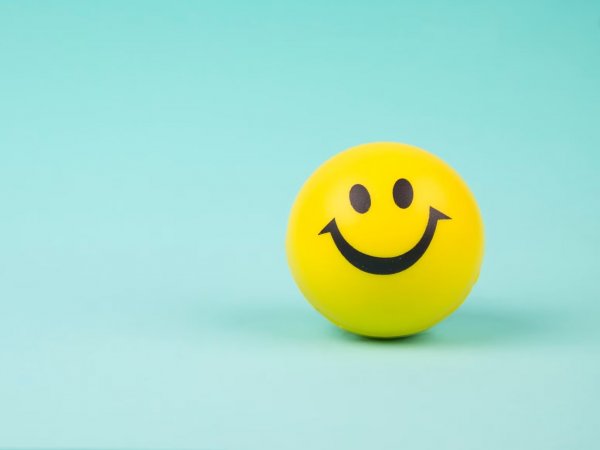 Cara feliz amarilla en un fondo celeste para representar la serotonina