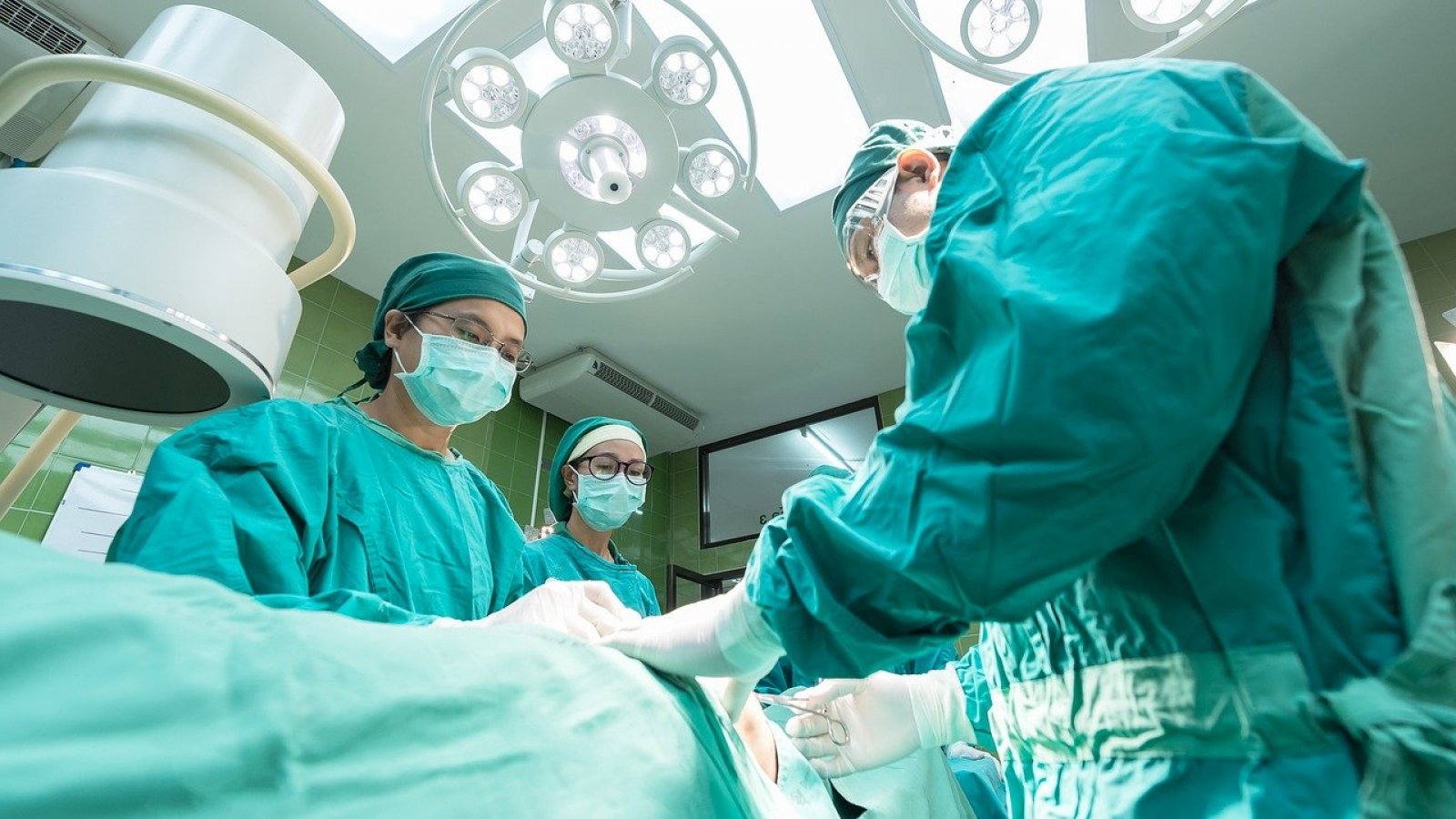 Doctores operando a una persona al interior de pabellón.