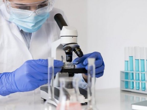 Científico mirando a través de un microscopio.