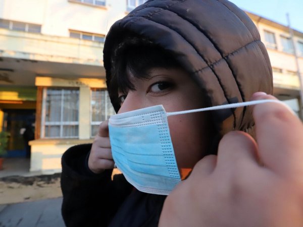 Niño poniéndose una mascarilla