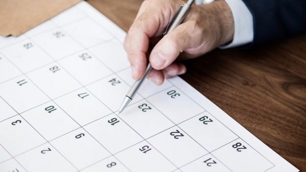 Mano de una persona revisando el calendario.