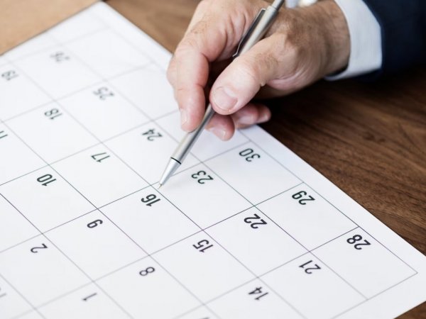 Mano de una persona revisando el calendario.