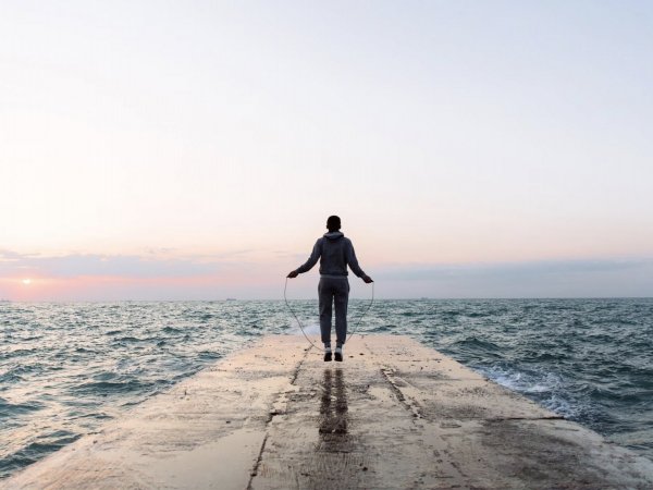 Persona saltando la cuerda frente al mar