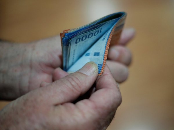 Mano sujetando billetes.