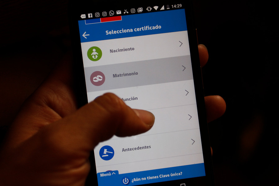 Teléfono con los certificados del Registro Civil en pantalla.