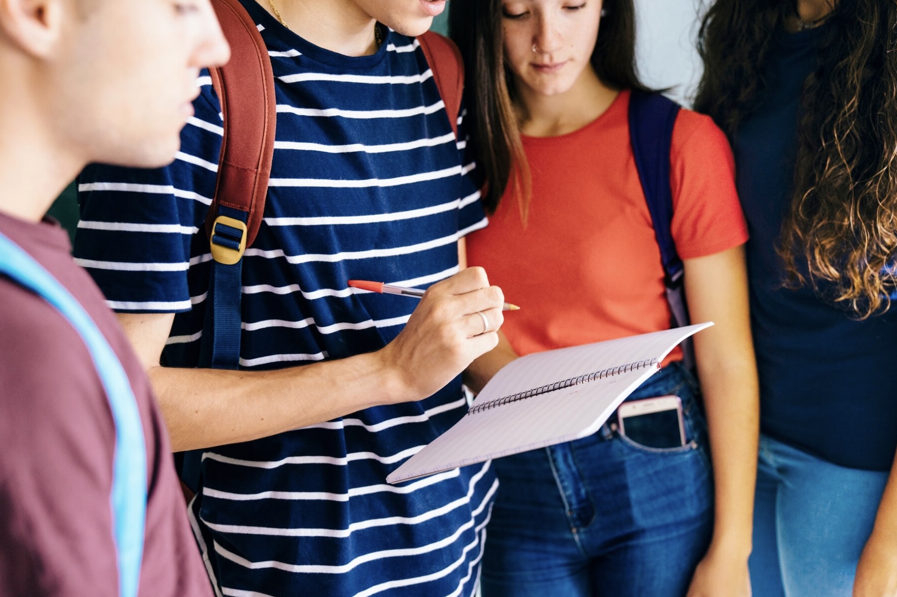 Cuatro universitarios revisando un cuaderno