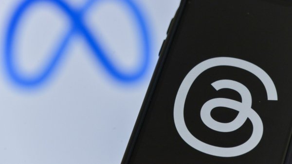 Logo de Meta en un computador y teléfono celular con el logo de Threads.