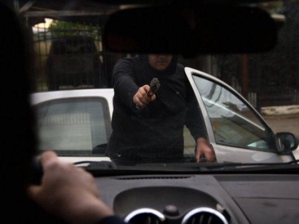 Delincuente amenaza con un arma.