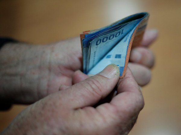 Mano sujetando billetes de diferentes montos.