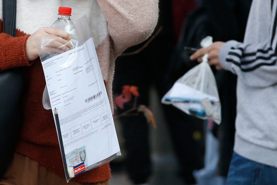 Estudiantes cargando lápiz y papel para la PAES