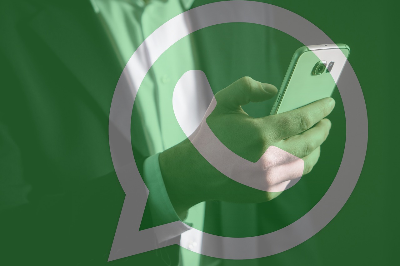 Whatsapp. Logo difuminado. Persona con celular. 