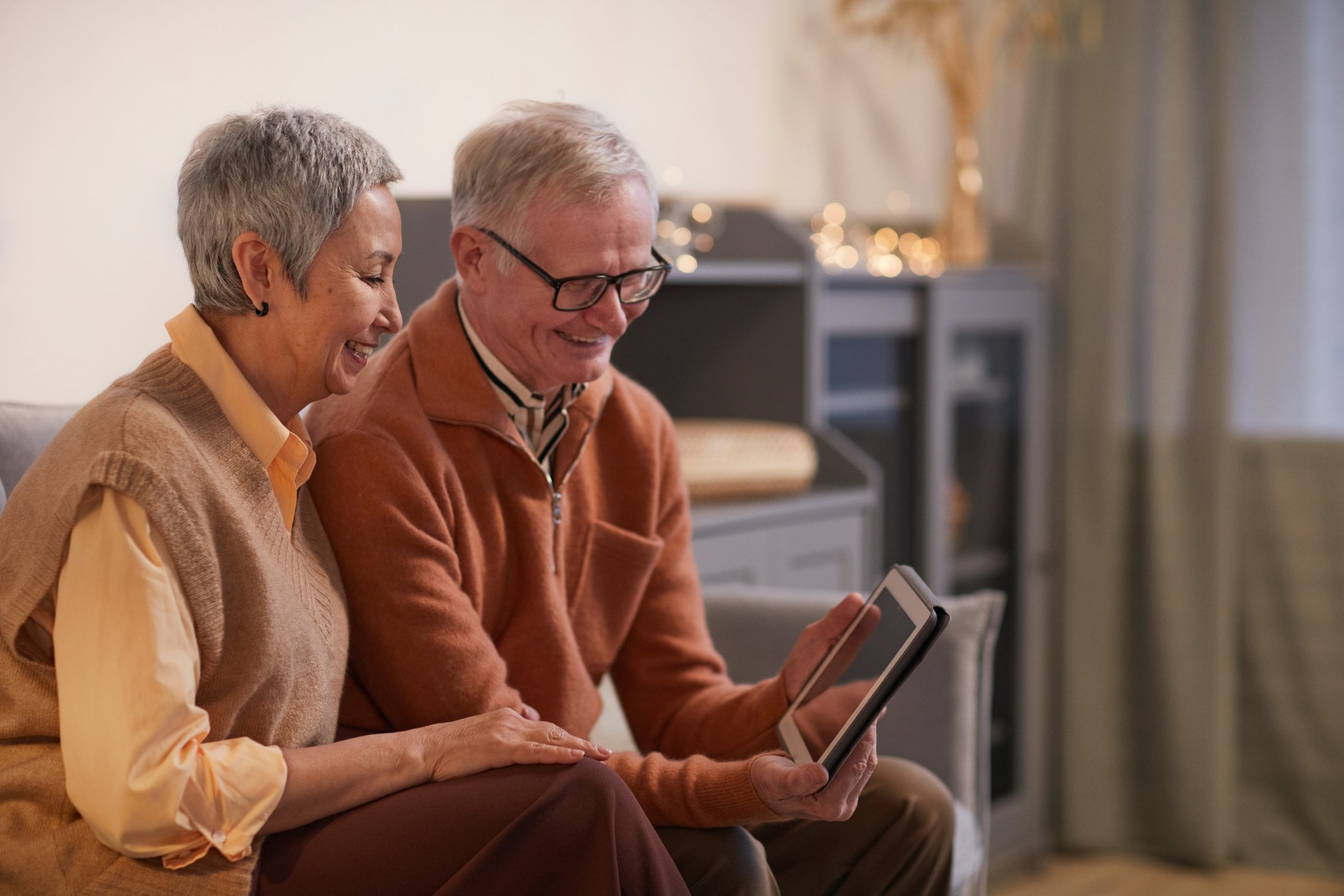 Mensajes de cumpleaños. Pareja de abuelos viendo una tablet. 