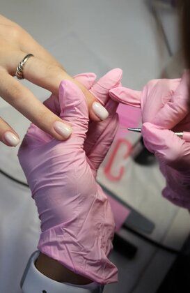 Manicurista trabajando en uñas de gel