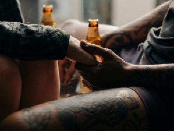 Pareja con tatuajes tomadas de la mano