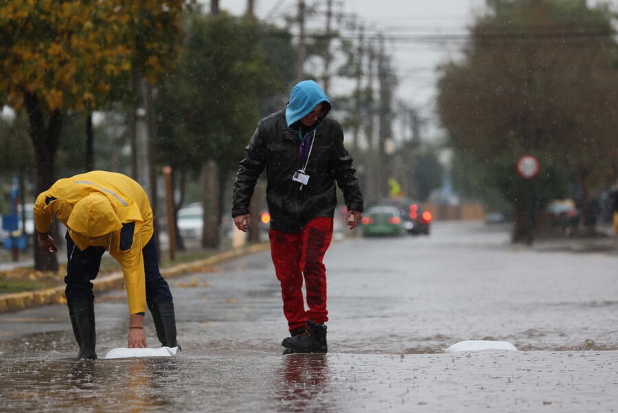 Personas bajo la lluvia en Santiago