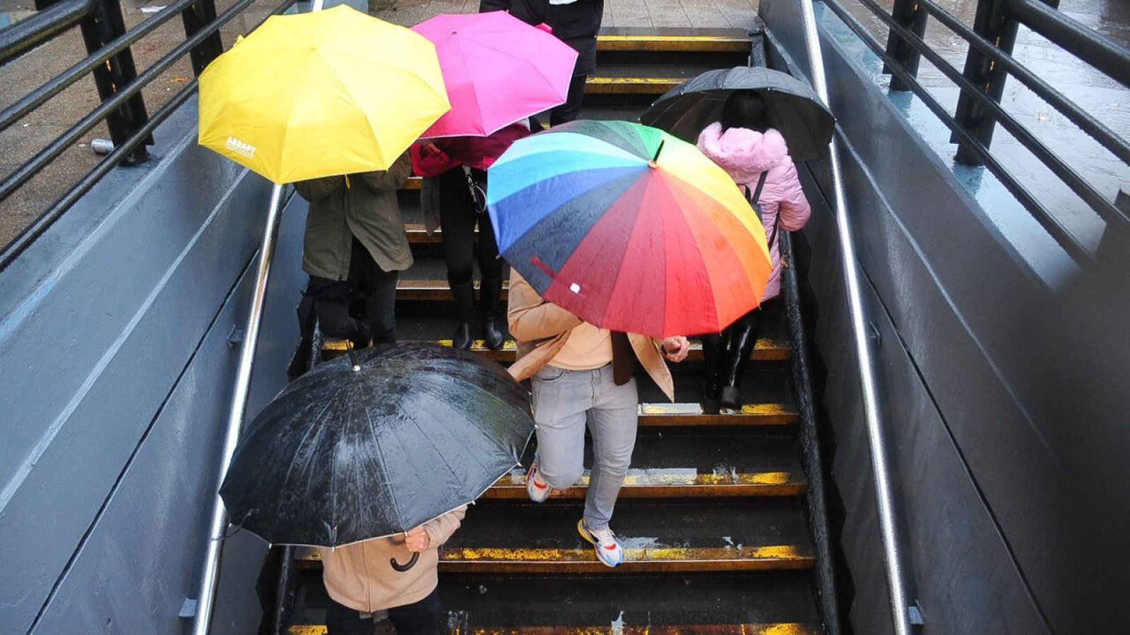 Sistemas frontales. Lluvia en Santiago. Personas con paraguas.