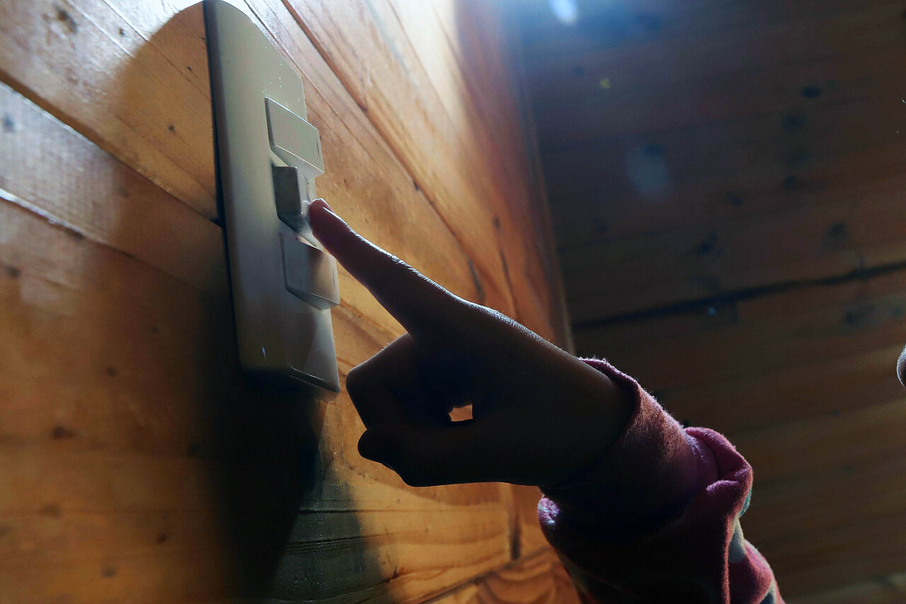 Dedo apagando la luz. Subsidio luz