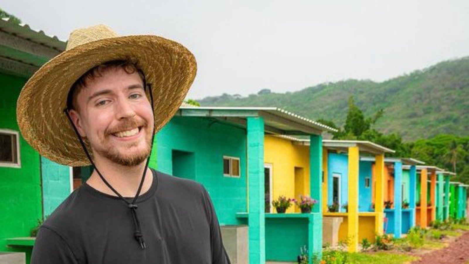 James Donaldson, alias MrBeast, posando en frente de las casas que construyó en su nuevo video