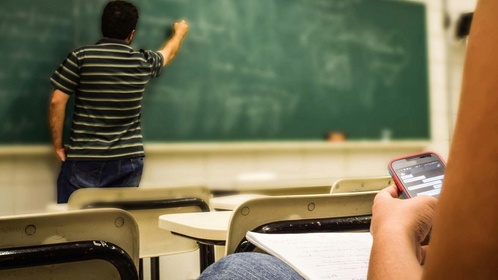 Estudiantes utilizando teléfonos celulares en el aula para actividades educativas. Chile, 2024.