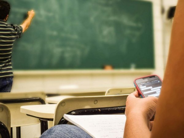 Estudiantes utilizando teléfonos celulares en el aula para actividades educativas. Chile, 2024.
