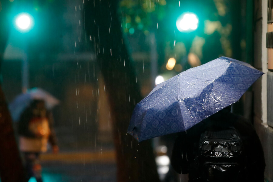 Lluvia. Personas bajo la lluvia con paraguas.