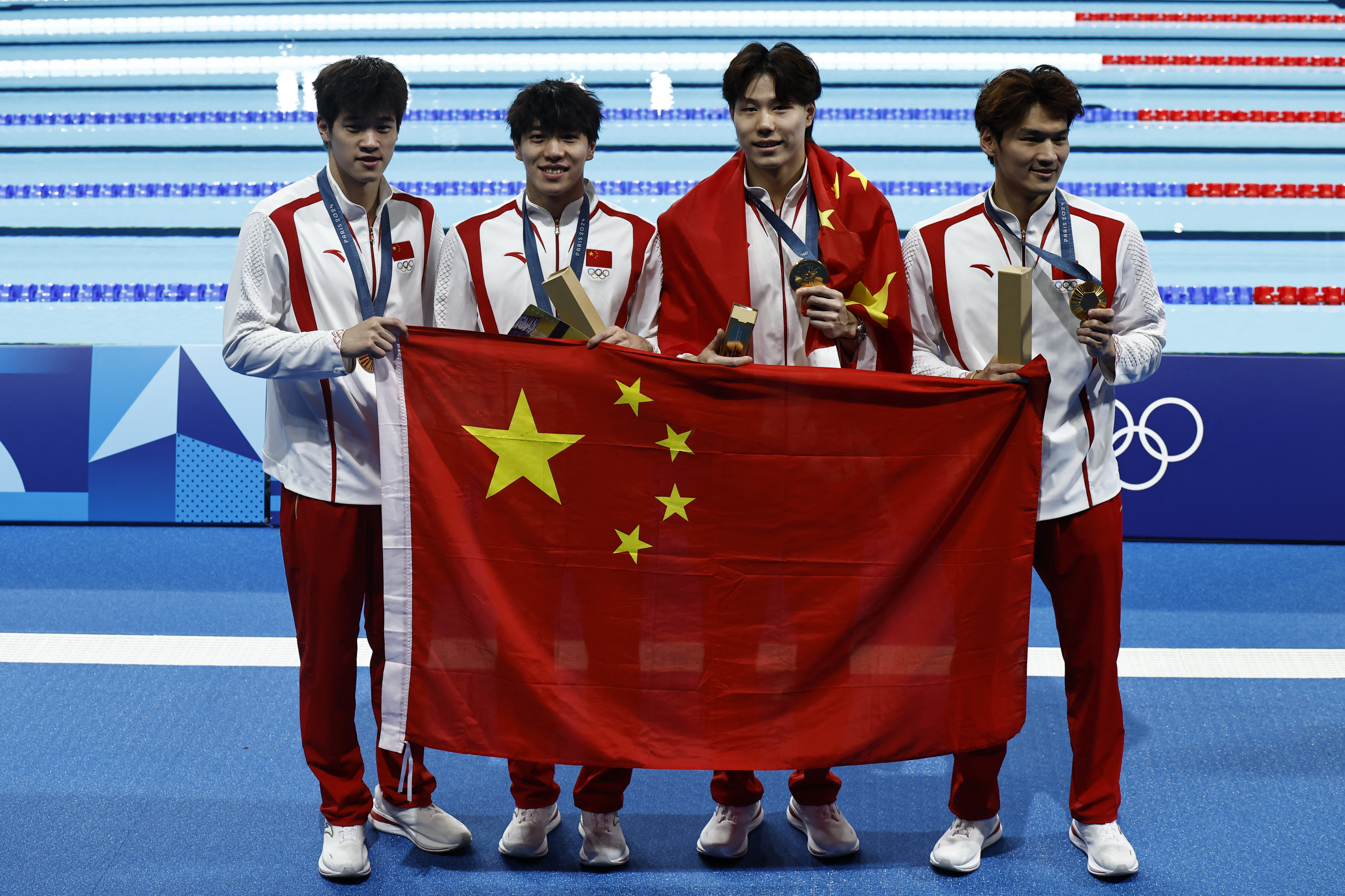 Jiayu Xu, Haiyang Qin, Jiajun Sun y Zhanle Pan recibiendo la medalla de oro