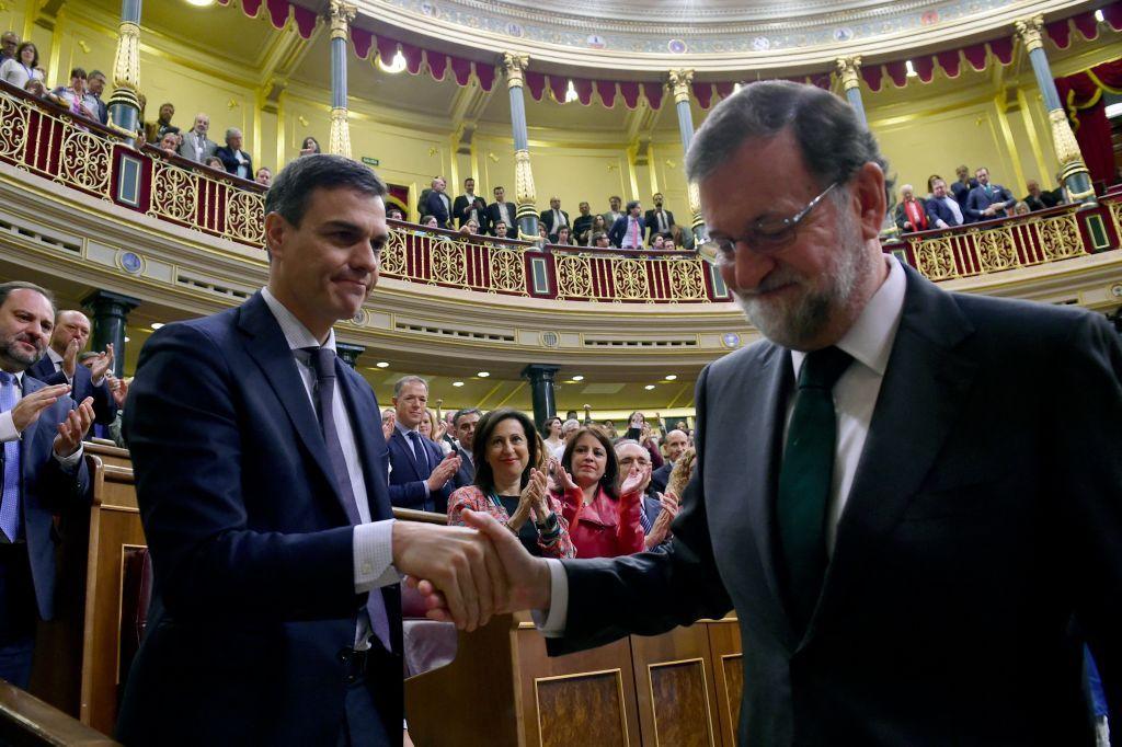 El socialista Pedro Sánchez le da la mano a su antecesor, el conservador Mariano Rajoy