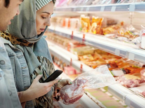 Personas revisando una carne envasada.