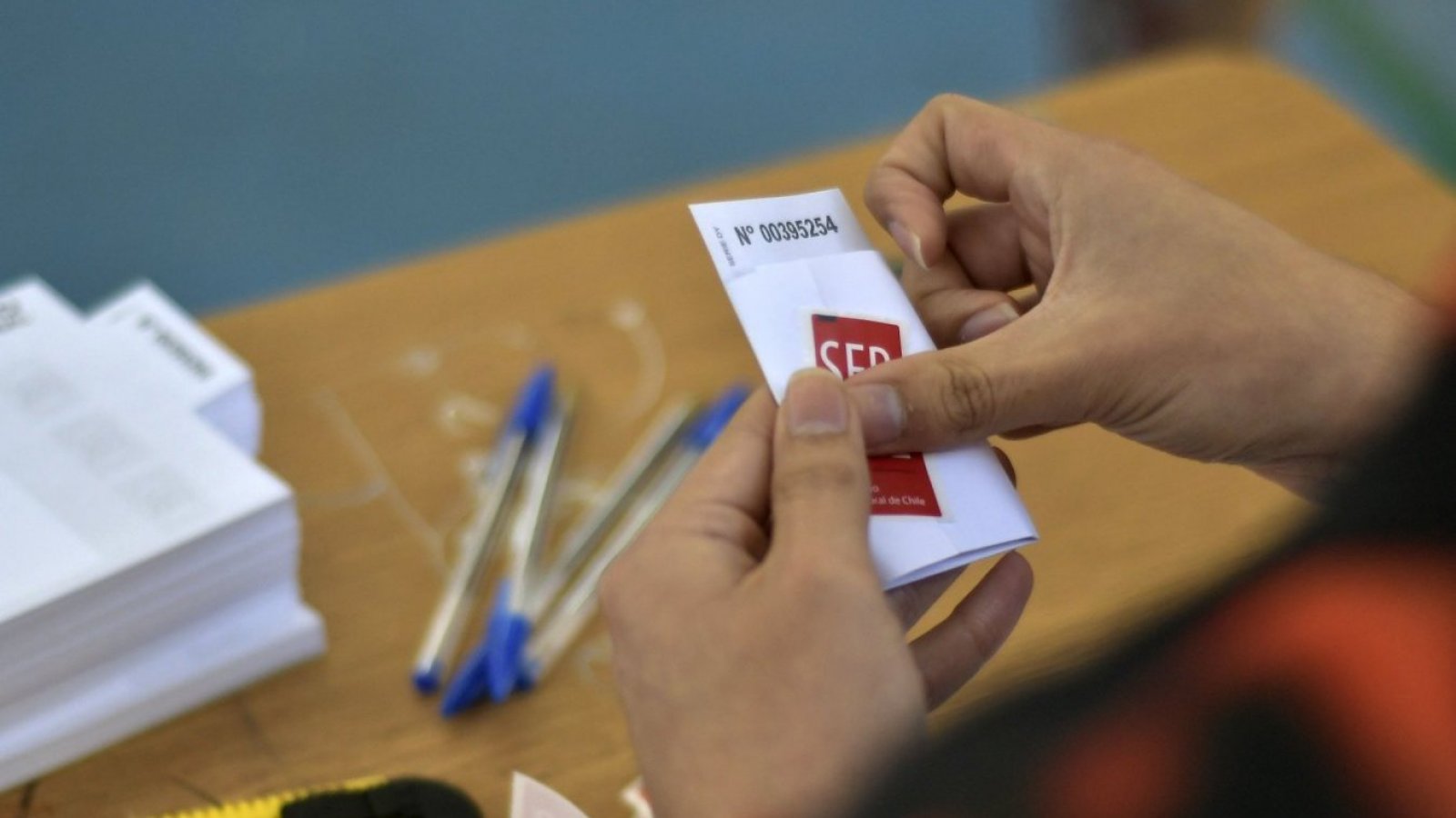 Vocal de mesa sostiene un voto en su mano en el Colegio Adventista