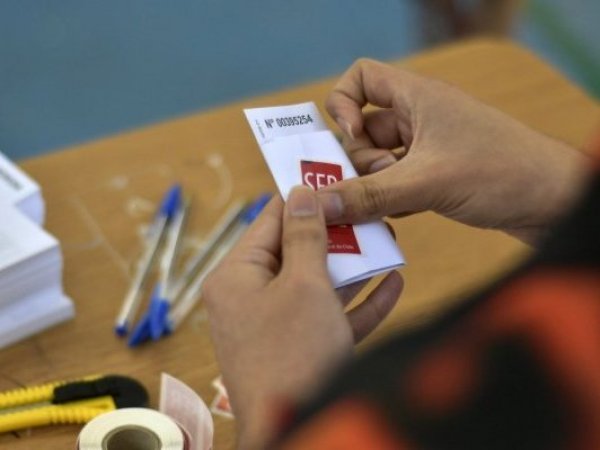 Vocal de mesa sostiene un voto en su mano en el Colegio Adventista