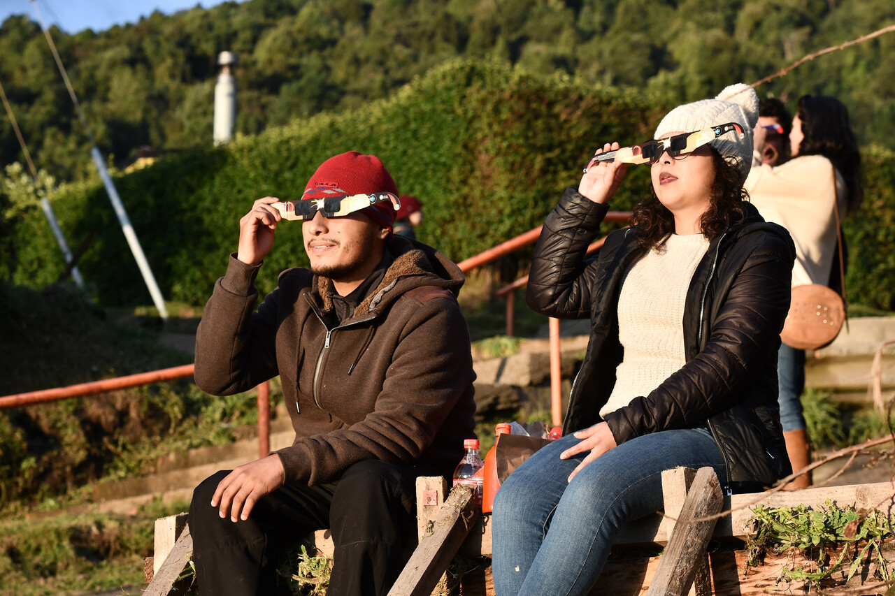 Eclipse solar anular. Personas viendo el eclipse.