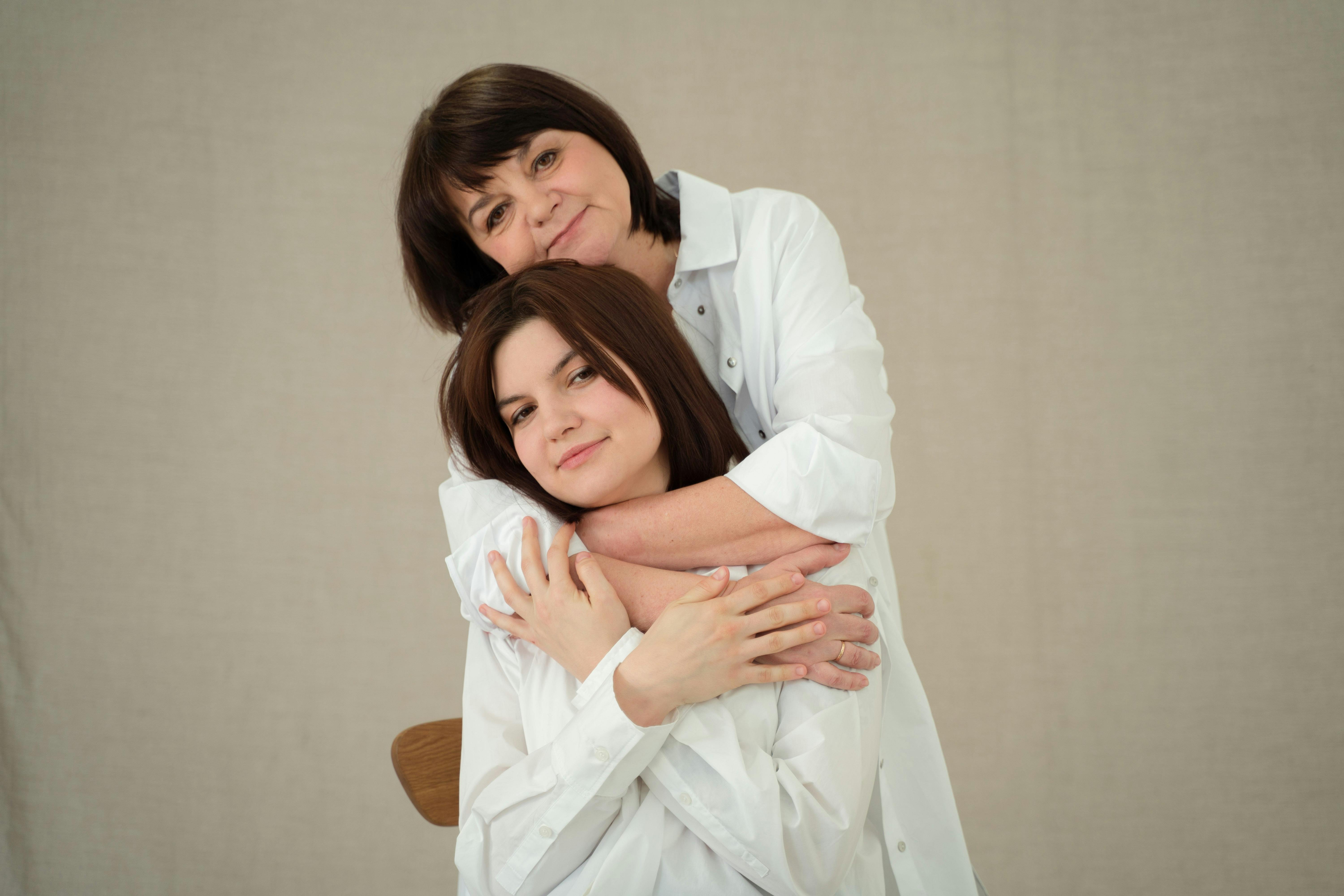 Madre abrazando a hija por la espada