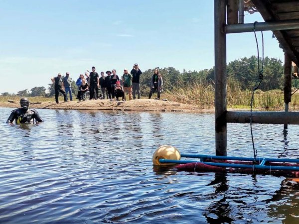 Voluntarios instalando dispositivos de pelo en el humedal de Mantagua para combatir la contaminación.