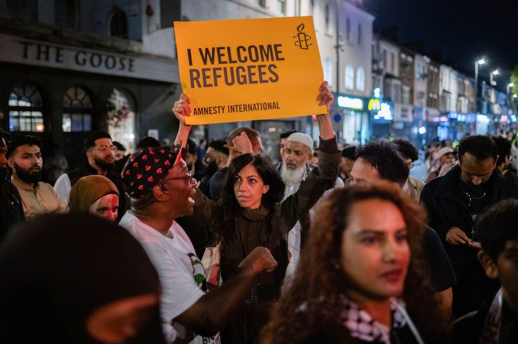 Una mujer con una pancarta que dice: "Yo les doy la bienvenida a los refugiados" durante una contramanifestación, después de que una serie de disturbios contra la inmigración sacudiera Reino Unido en agosto de 2024.