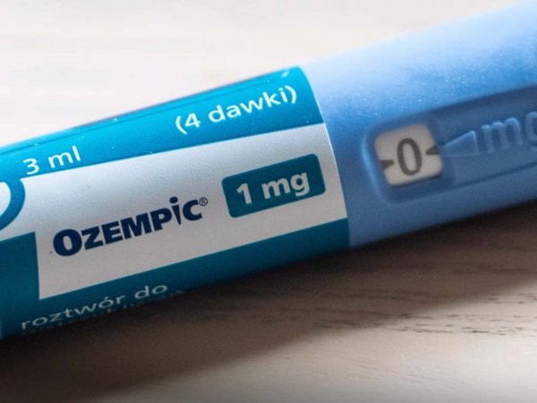 Imagen de un frasco de Ozempic junto a una jeringa en un fondo neutro, destacando su uso médico.