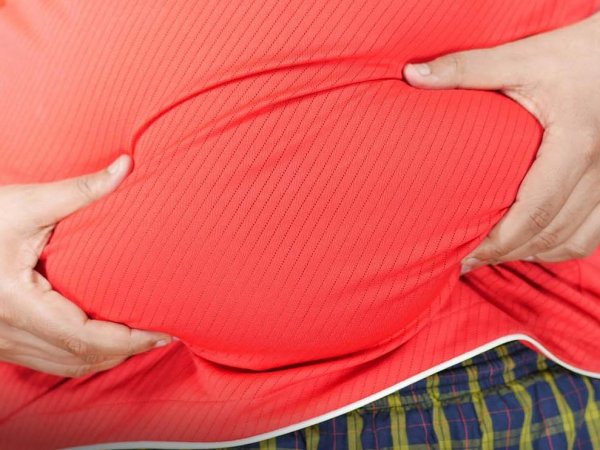 Persona con sobrepeso sosteniendo una balanza, reflejando la crisis de obesidad proyectada para 2050.