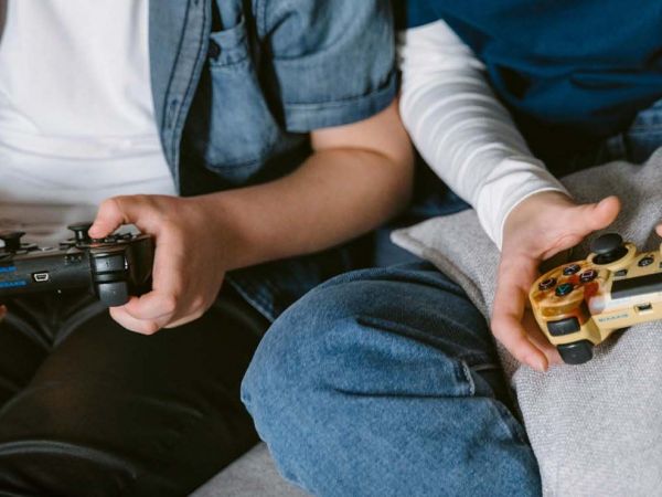 Niño jugando videojuegos en casa con auriculares y joystick.